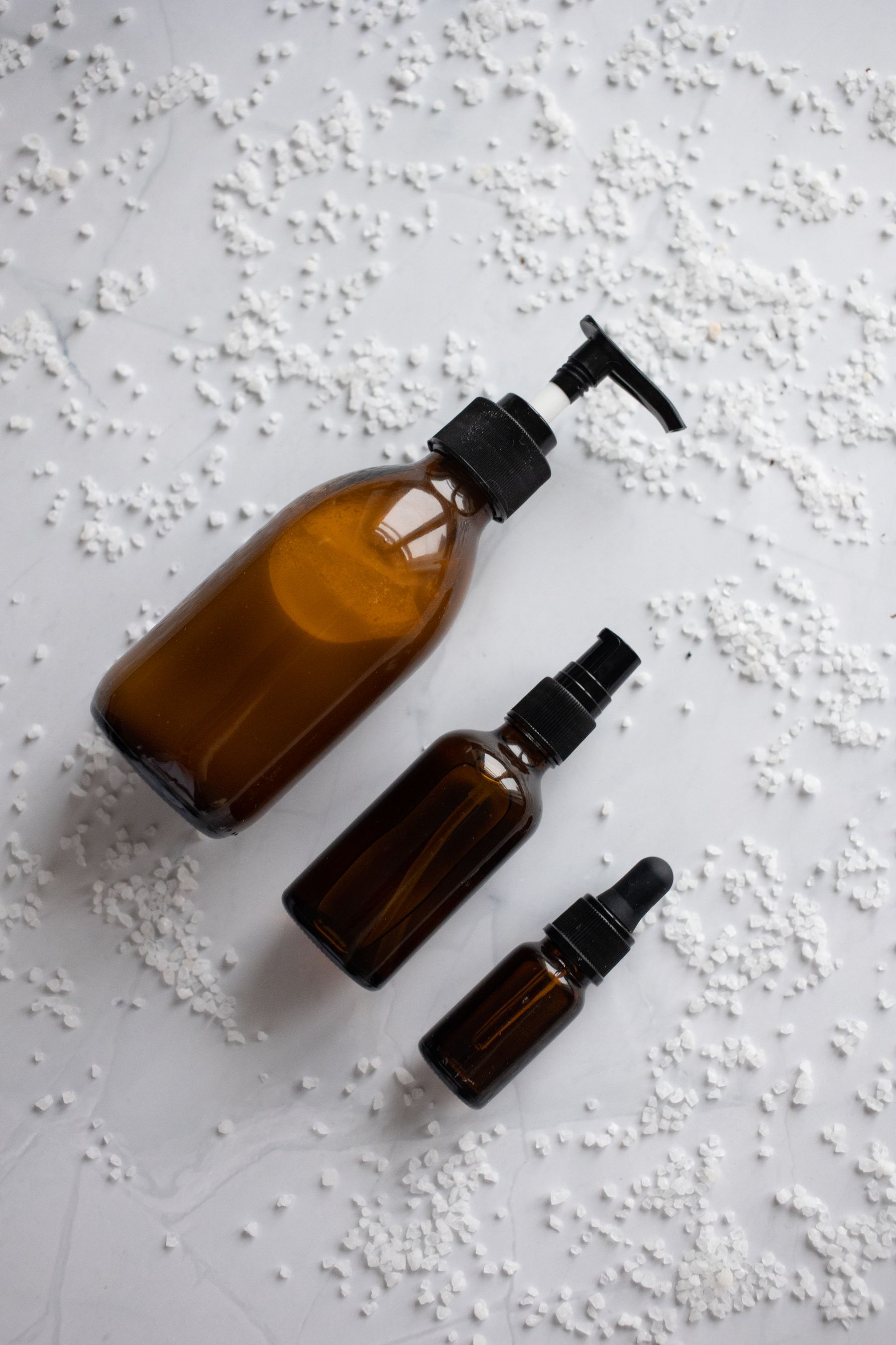 Amber skincare bottles styled in a calm neutral setting